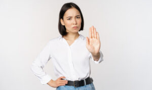 portrait-young-woman-extending-one-hand-stop-taboo-sign-rejecting-declining-something-standing-white-background-copy-space
