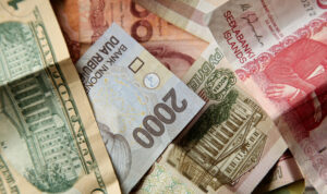 high-angle-closeup-shot-pile-banknotes-wooden-surface